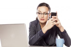 businesswoman follows the computer and texting on the phone